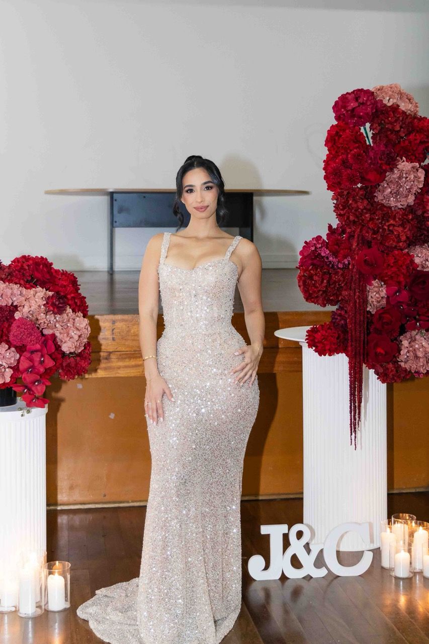 The bride-to-be in a sequinned gown beside red roses