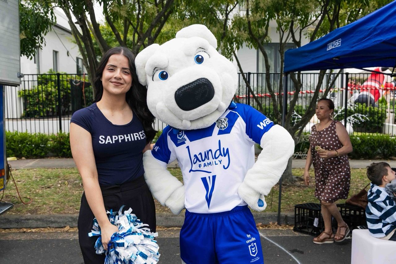 A cheerleader poses with a rugby league mascot