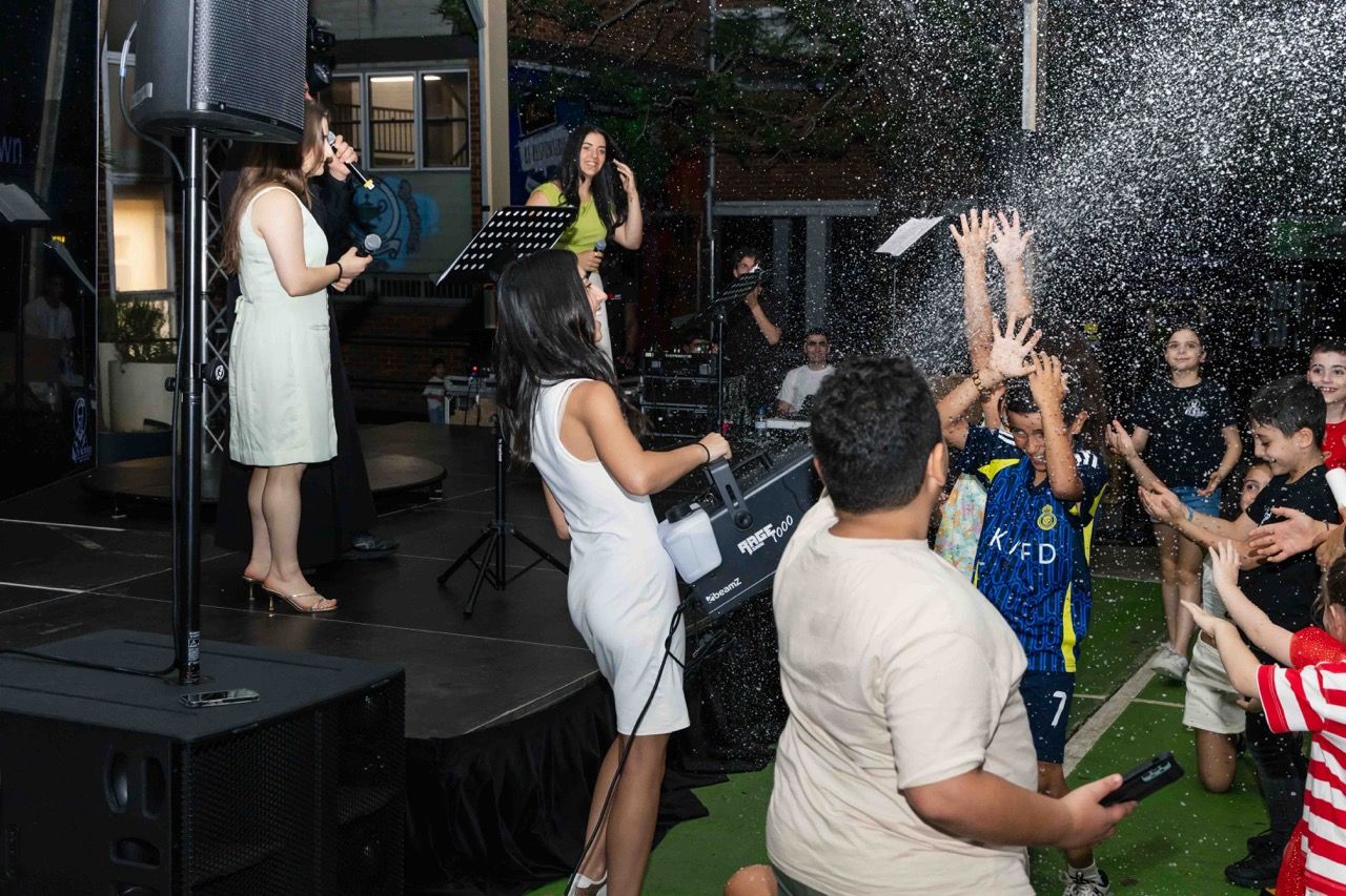 Kids cheer as snow sprays over the crowd